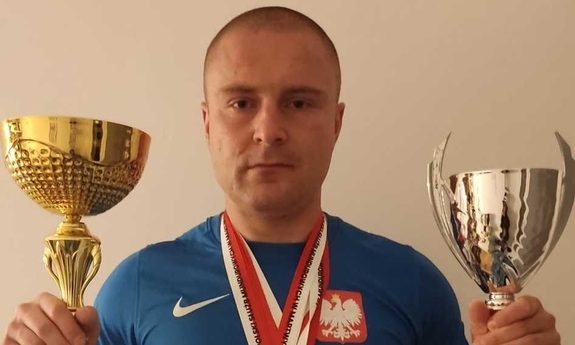 policjant trzymający dwa puchary
