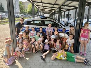 Policjantka pozuje do zdjęcia z grupą dzieci.