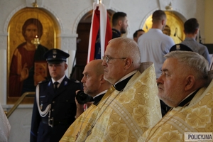 policjanci ze sztandarem wraz z duchownymi