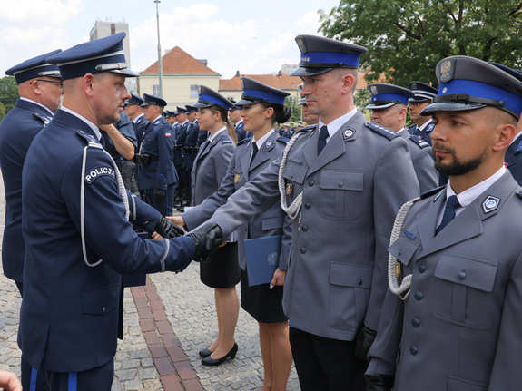 komendant główny policji podaje rękę policjantowi