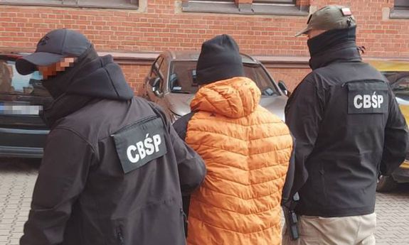 policjanci prowadzą zatrzymanego