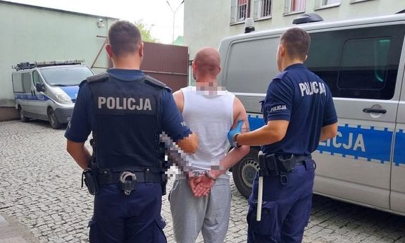 policjanci stoją z zatrzymanym
