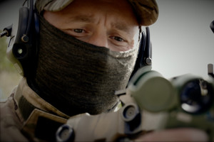 Stopklatka z filmu: funkcjonariusz z karabinem w dłoni