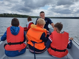 Policjant na łodzi z grupą dzieci.