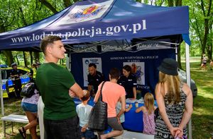 Policjanci w namiocie profilaktycznym z uczestnikami pikniku.