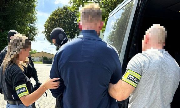 policjanci idą z zatrzymanym