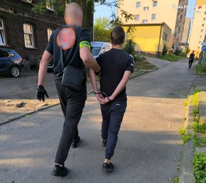 policjanci prowadzą zatrzymanego