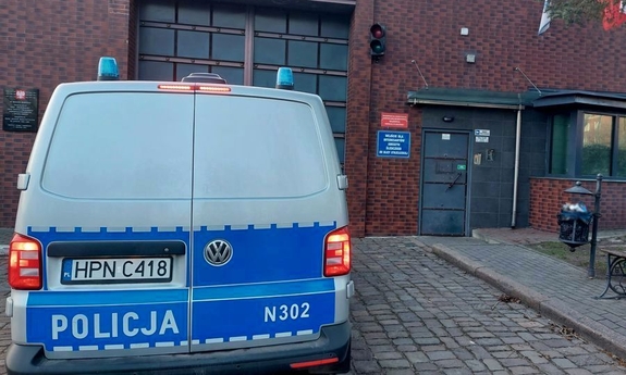 na zdjęciu radiowóz stoi przed bramą wjazdową do aresztu śledczego