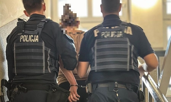 dwóch policjantów prowadzi zatrzymaną kobietę