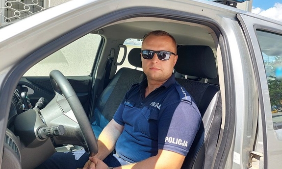 umundurowany policjant siedzi w radiowozie