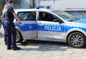 policjanci  z zatrzymanym wsiadają do radiowozu