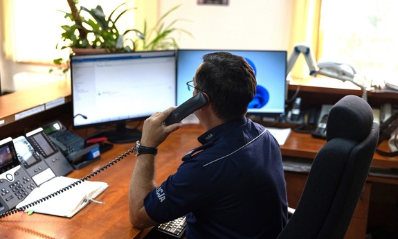 Dyżurny za biurkiem rozmawia przez telefon