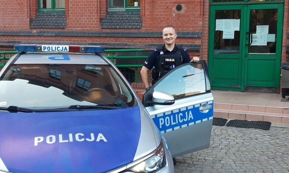 umundurowany policjant przy radiowozie