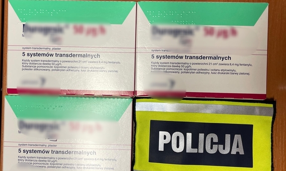 trzy opakowania z plastrami i opaska z napisem Policja