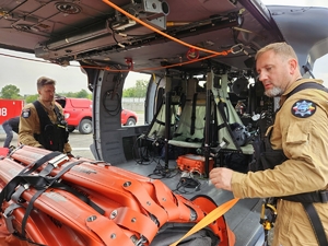 policjanci i strażacy w trakcie ćwiczeń z wykorzystaniem policyjnego Black Hawka