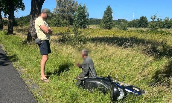 policjant i kierujący skuterem w rowie