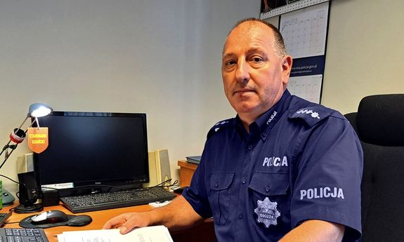 policjant siedzi przy biurku