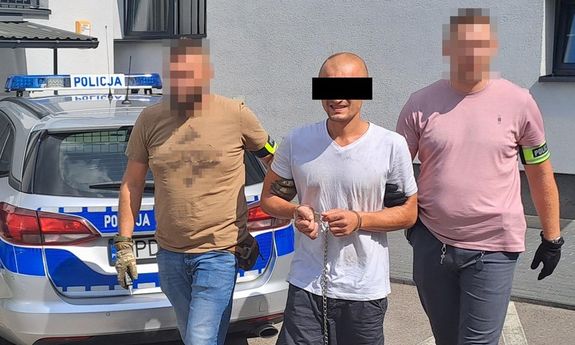 policjanci prowadzą zatrzymanego