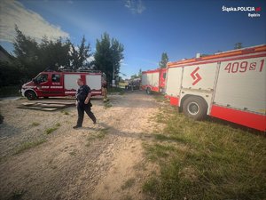 wozy strażackie oraz idący policjant