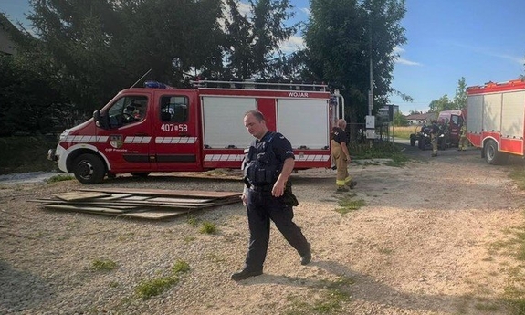 wozy strażackie oraz idący policjant