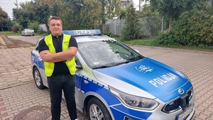 policjant stoi przy radiowozie