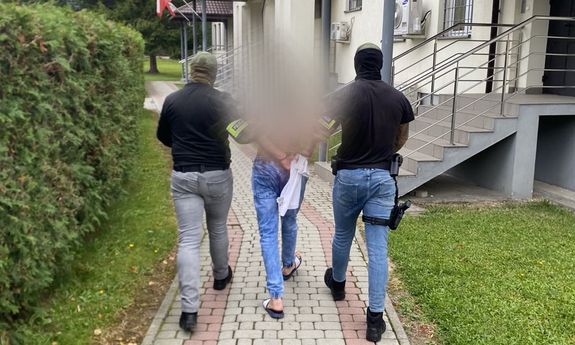 policjanci prowadzą zatrzymanego