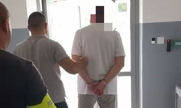 Policjanci prowadzą zatrzymanego