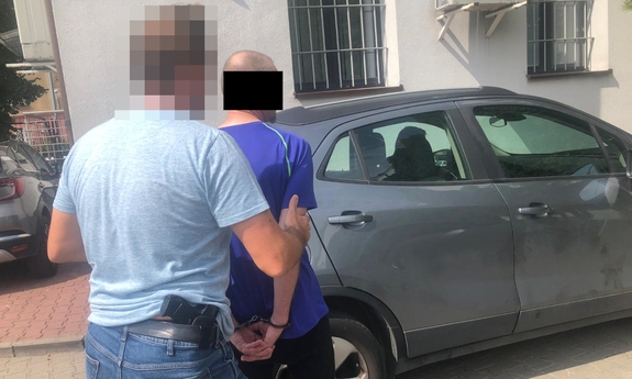 policjant prowadzi zatrzymanego mężczyznę
