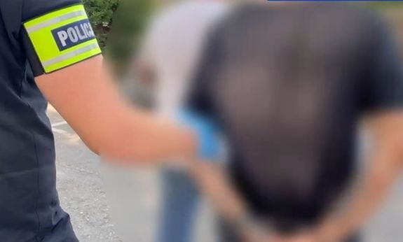 Policjant idzie z zatrzymanym