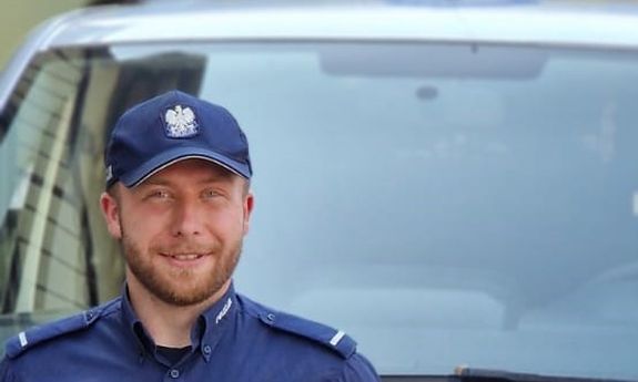 policjant, w tle radiowóz