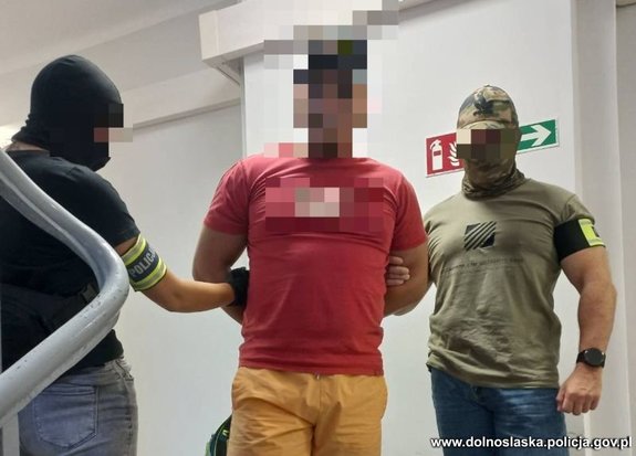 policjanci stoją z zatrzymanym