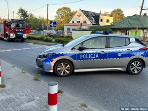 radiowóz, w tle wóz strażacki i budynki