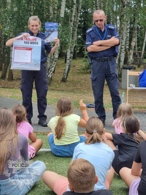 Para policjantów z grupą dzieci podczas prelekcji.