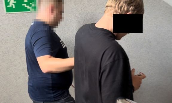 POLICJANT w cywilu prowadzi zatrzymanego