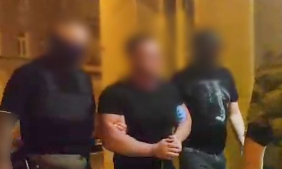 Policjanci w cywilu idą z zatrzymanym