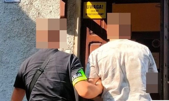 policjant prowadzi zatrzymanego