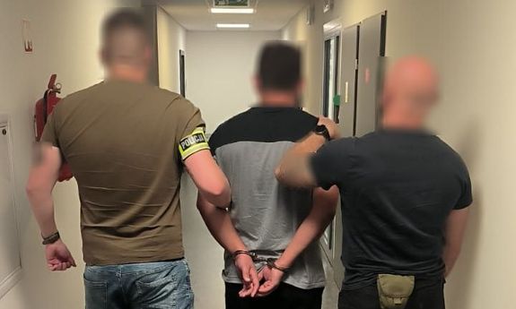policjanci idą z zatrzymanym