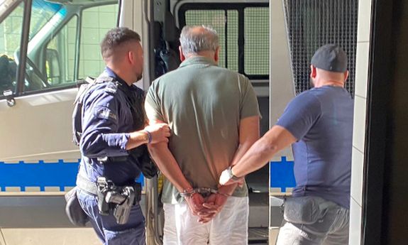policjanci idą z zatrzymanym