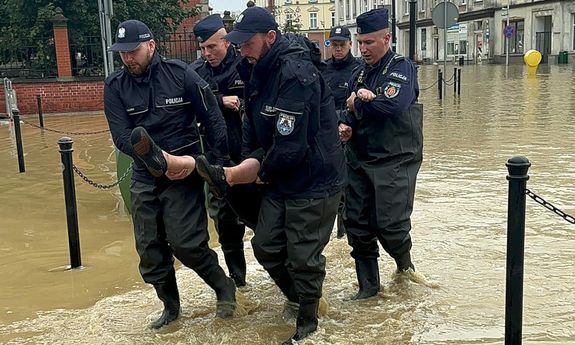 policjanci idą w wodzie i niosą mężczyznę