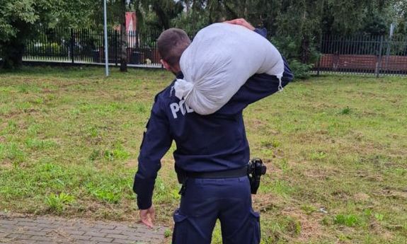 policjant niesie worek z piaskiem
