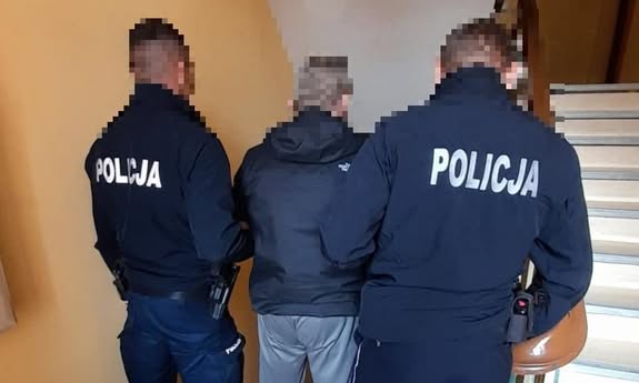 policjanci stoją z mężczyzną na klatce schodowej
