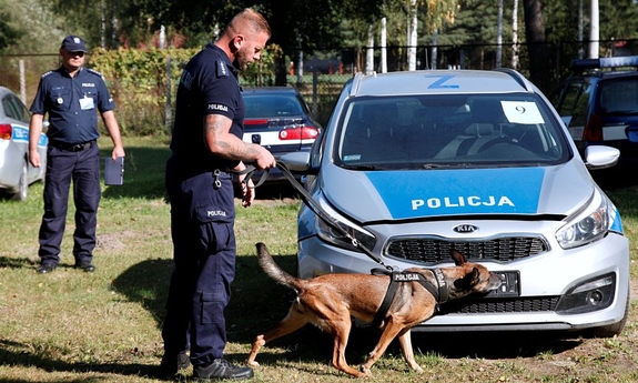 policjant z psem na smyczy przy radiowozie podczas jednej z konkurencji