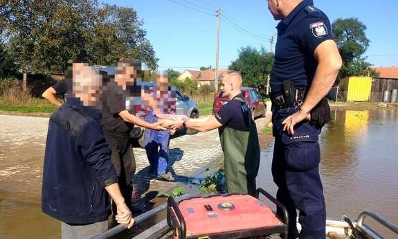 policjanci przekazujący żywność mieszkańcom