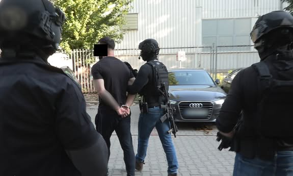 policjanci idą z zatrzymanym