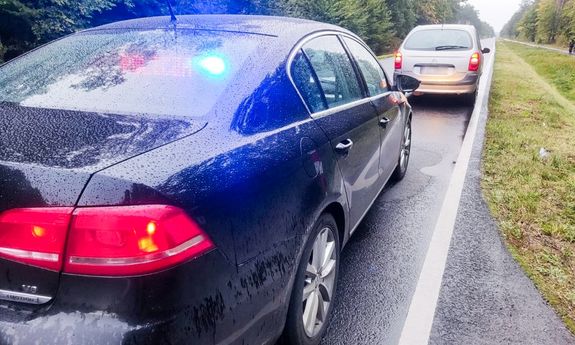 Osobowy citroen stoi na jezdni a za nim nieoznakowany policyjny radiowóz - widok z tyłu.