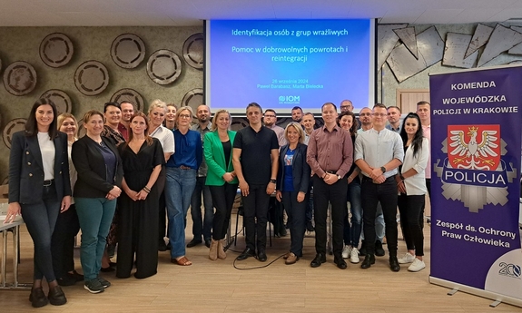 Uczestnicy seminarium stoją w grupie pozując do zdjęcia.