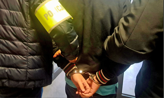 dwaj policjanci prowadzą zatrzymanego