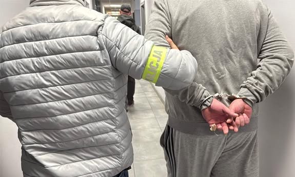 policjant idzie z zatrzymanym