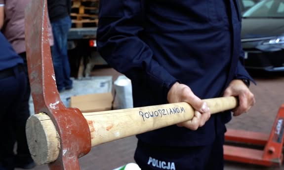 policjant trzyma sprzęt do naprawy ścian