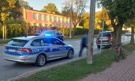 radiowóz stoi przed przejściem dla pieszych.